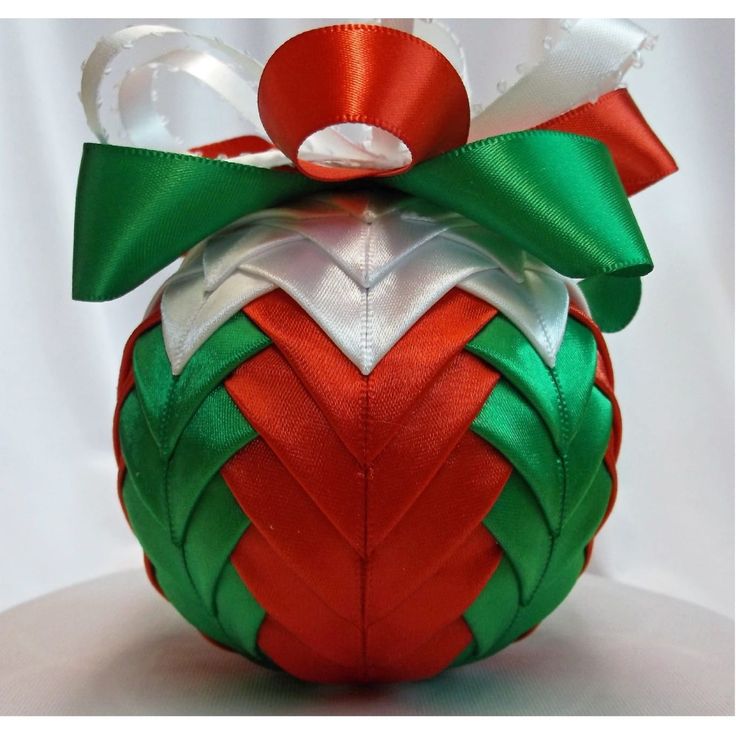 an ornament shaped like a christmas ball with a green and red bow on top