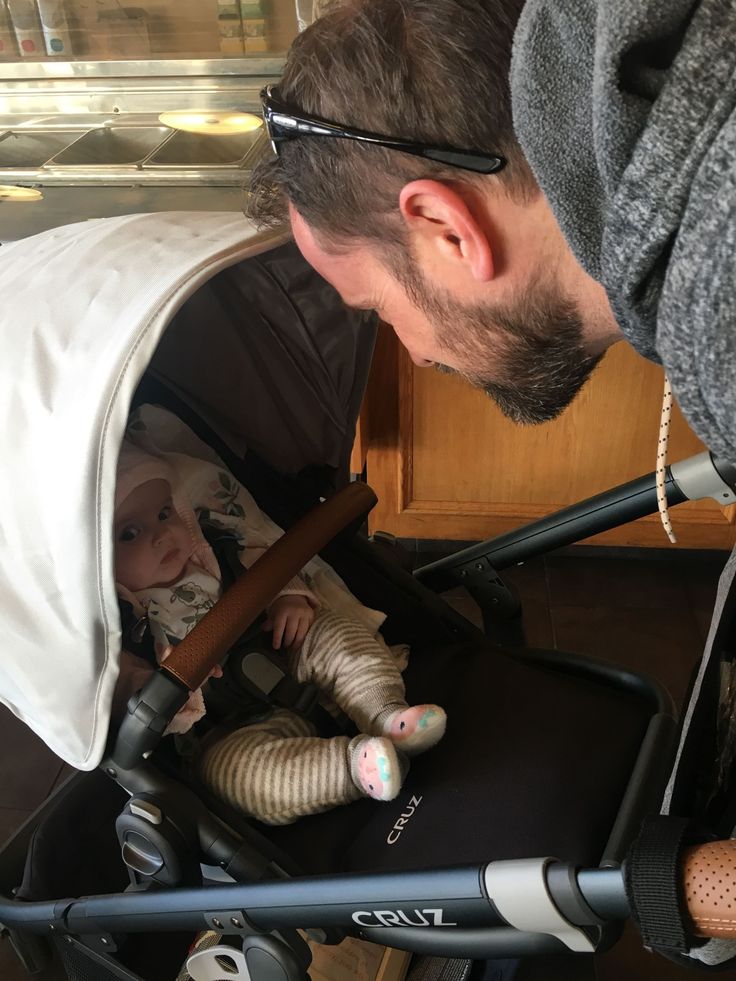 a man looking at a baby in a stroller