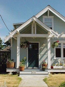 a small white house with flowers on the front porch