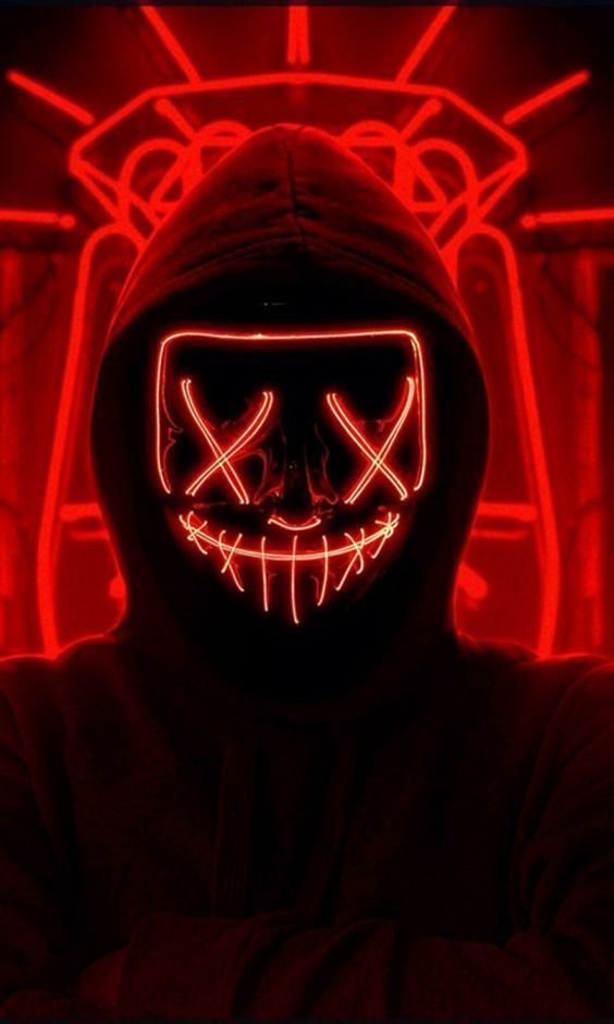 a person wearing a mask with red lights on their face and hands in front of them