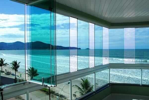 an ocean view from the inside of a building with glass walls and balconies