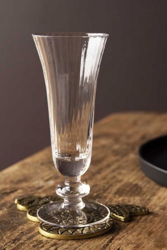 a clear glass vase sitting on top of a wooden table next to a black plate