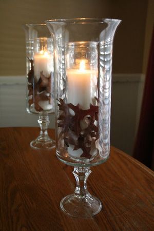 two clear glass vases with candles in them