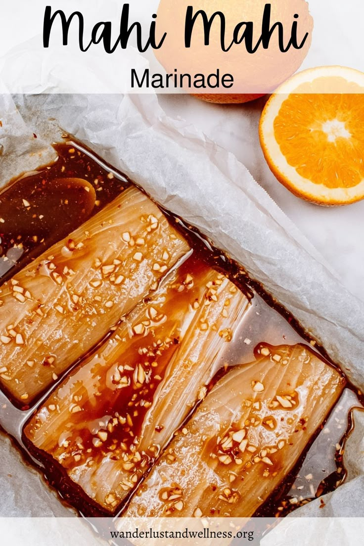 there is an orange and some food on the table with text overlay that reads, mahi mahi marinade