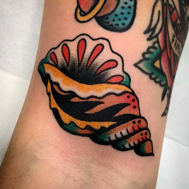 a colorful tattoo on the arm of a person with a seashell in its shell