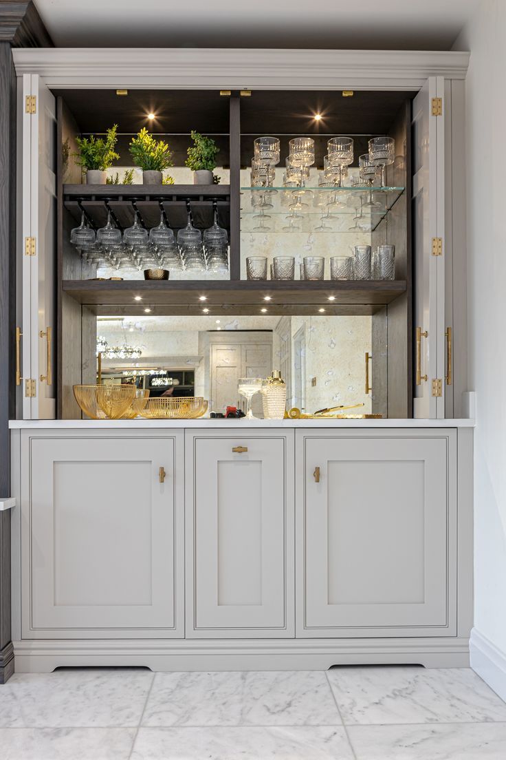 a kitchen with white cabinets and marble floors