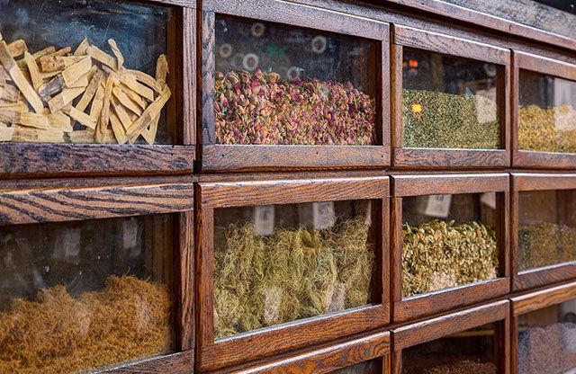 an assortment of dried herbs displayed in wooden display cases