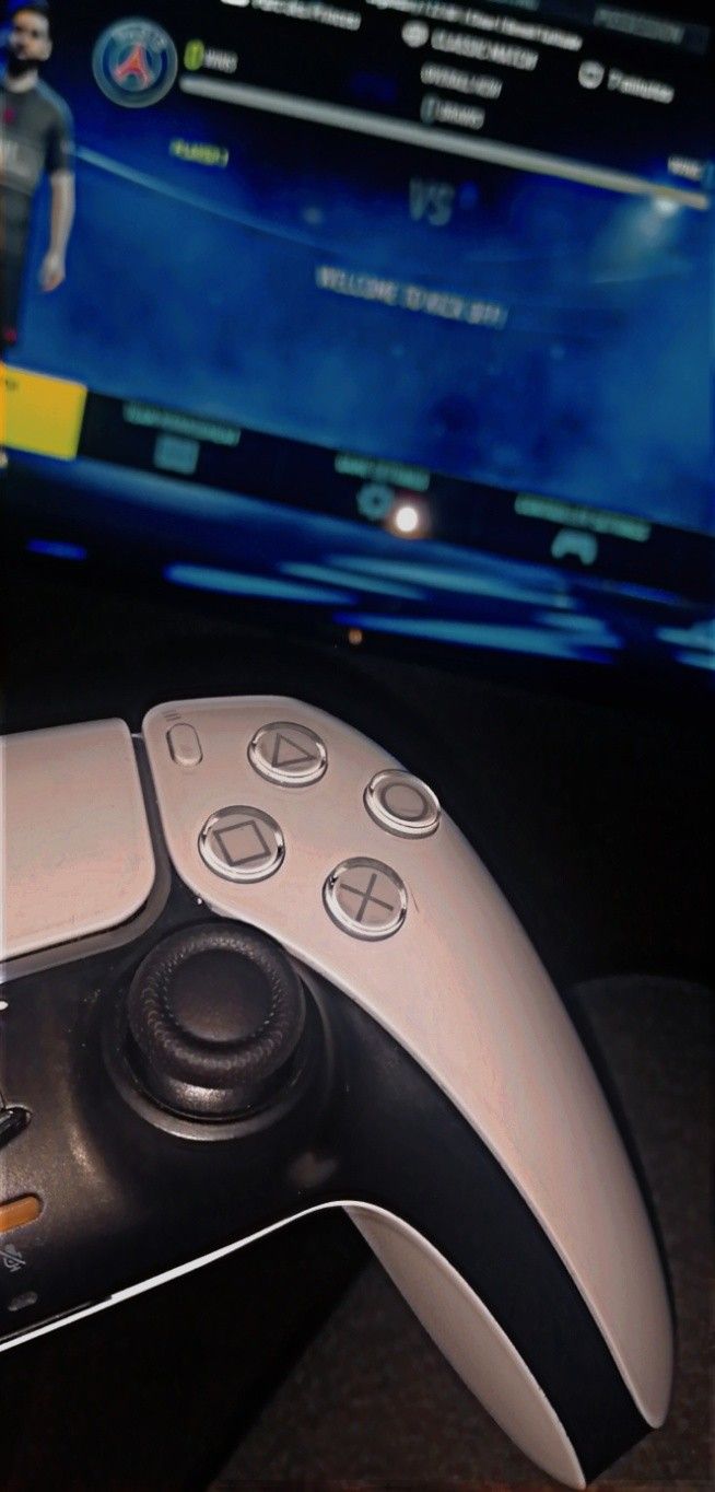 a video game controller sitting in front of a tv screen with an image of a man on it