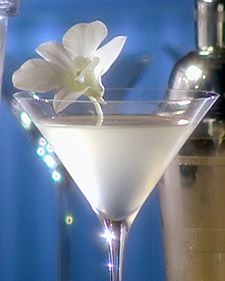 the martini is ready to be served with an orchid garnish on the rim