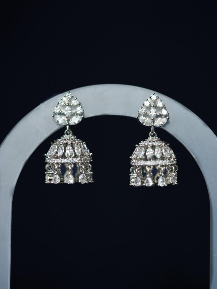 Adored for its dainty size and diamond-like sparkle, our Noori Mini Jhumka is a sophisticated silver CZ small jhumka perfect for everyday wear. This must-have unique South Asian earring is handmade and features white gold plating and shimmering cubic zirconia stones. Materials: Cubic zirconia, copper and brass alloy, rhodium plating Dimensions (L x W): 1.2 x 0.6 inches Weight: 5g (per mini jhumka) Festive Diamond Jhumkas With Latkans, Hand-set Diamond Jhumkas, Diamond Jhumkas With Latkans For Formal Occasions, Formal Diamond Jhumkas With Latkans, Festive Diamond Jhumkas For Formal Occasions, Silver Latkans Jewelry For Formal Occasions, Formal Silver Jewelry With Latkans, Cubic Zirconia Bridal Earrings For Festive Occasions, Elegant Party Danglers With Cutdana