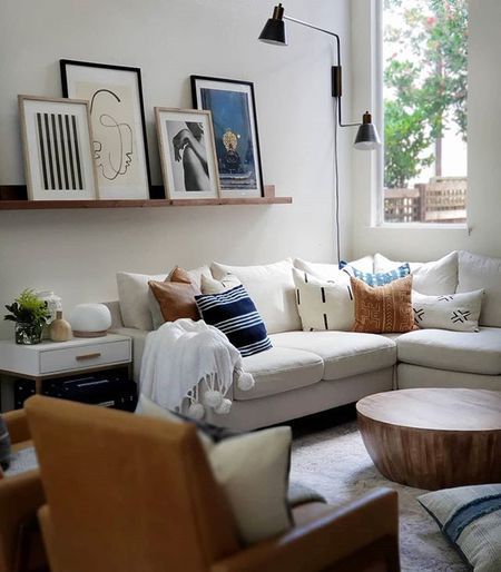 a living room filled with lots of furniture next to a wall mounted clock and window