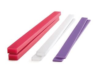 three different colors of toothbrushes are shown in this image, one is pink, the other is white