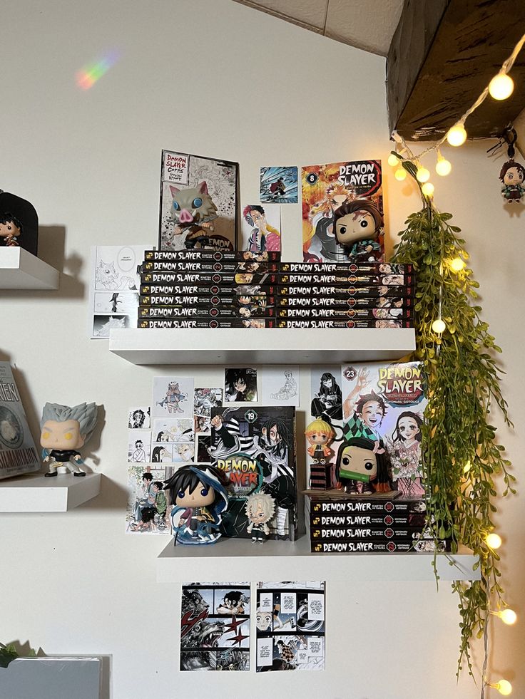 three white shelves filled with comic books on top of a wall next to a potted plant