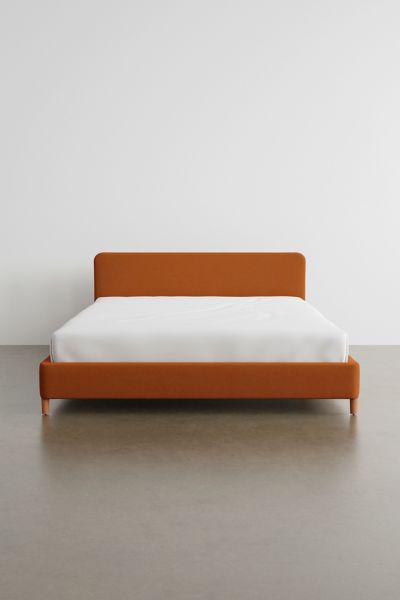 an orange and white bed sitting on top of a floor