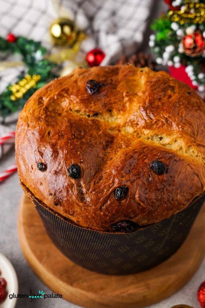 a loaf of blueberry bread sitting on top of a wooden cutting board next to christmas decorations