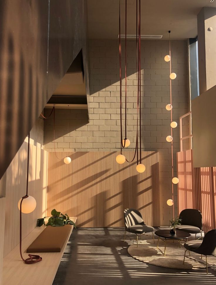 a living room filled with furniture and hanging lights