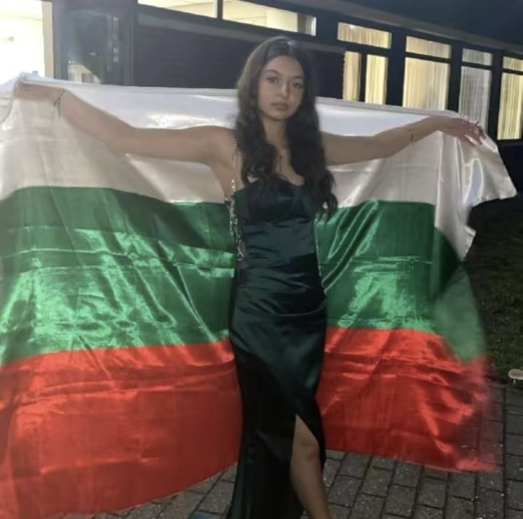 a woman standing in front of a large flag