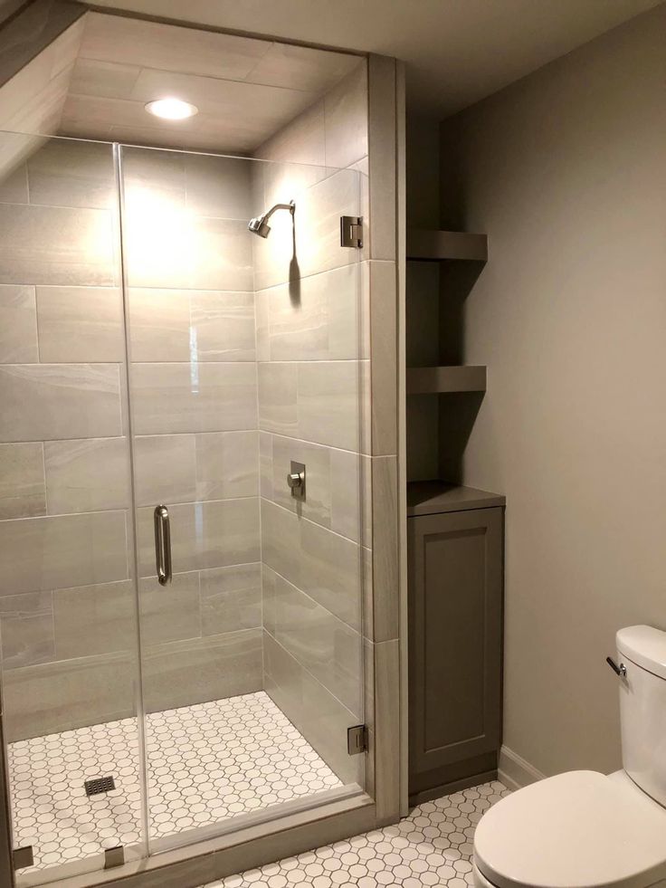 a white toilet sitting next to a walk in shower