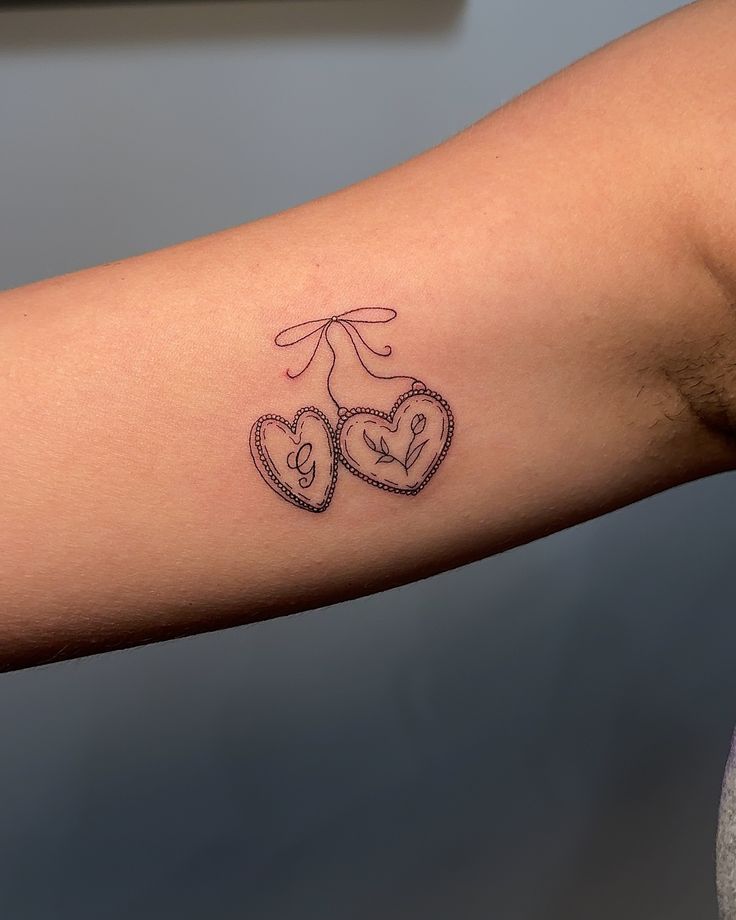 a couple of hearts tattoo on the arm