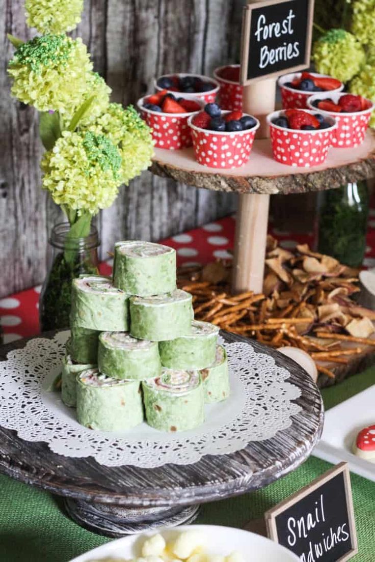 a table with desserts and cupcakes on it, along with other food items