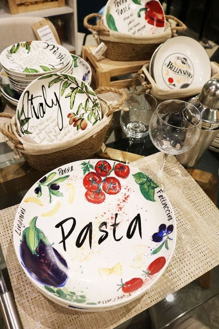 plates and bowls with the words pasta painted on them are sitting on display in a store