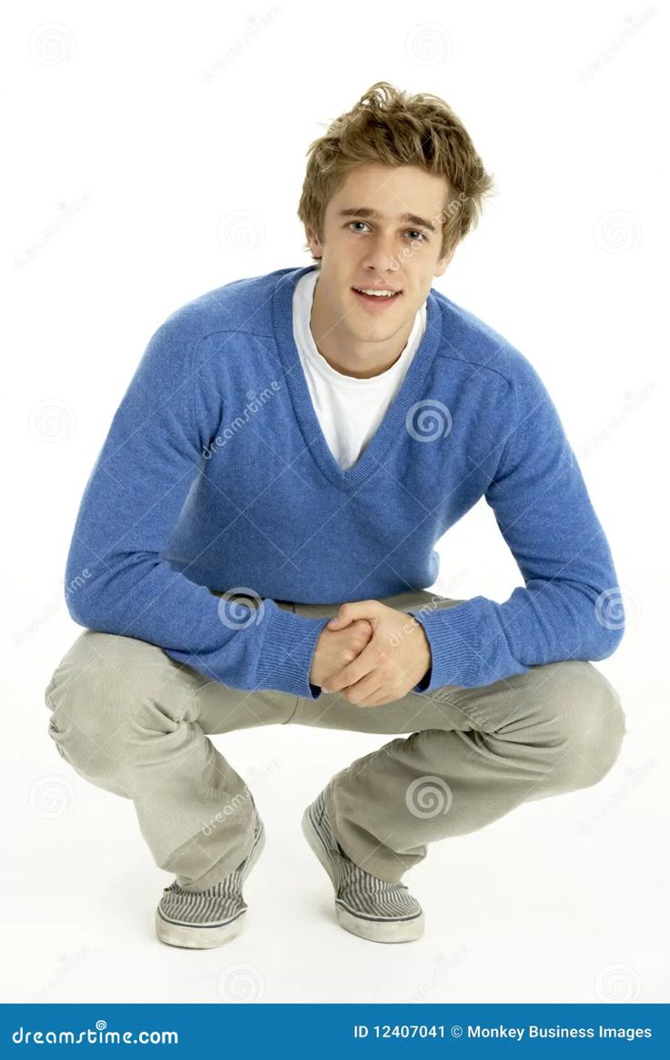 a young man in a blue sweater posing for the camera