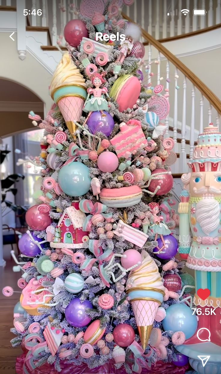 a pink christmas tree decorated with lots of colorful ornaments and decorations on top of it