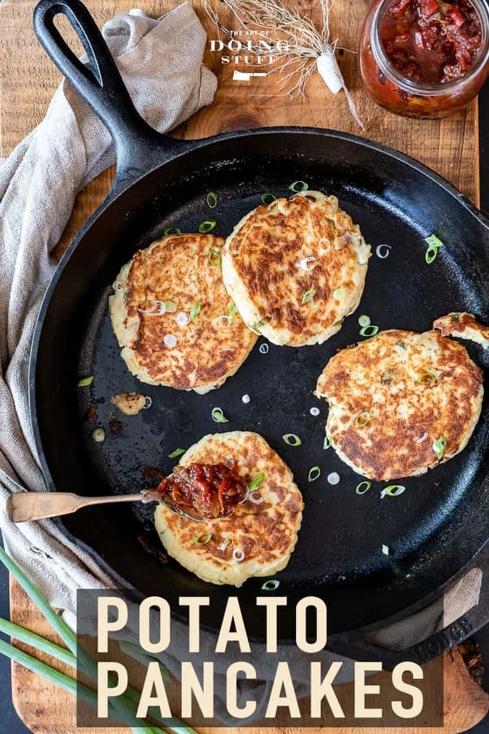 three pancakes are being cooked in a skillet on a wooden cutting board with text overlay that reads potato pancakes