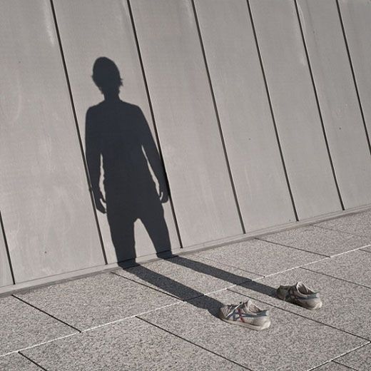 the shadow of a person standing in front of a wall with a sign that says i was already missing before the night i left