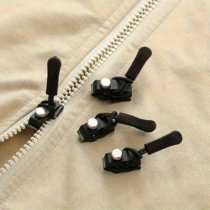 four zippers are attached to the side of a jacket with white buttons on them