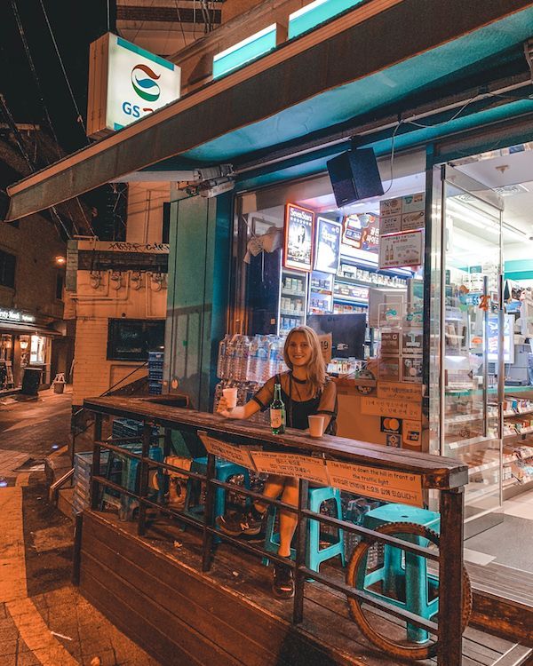 a woman sitting at a counter in front of a store