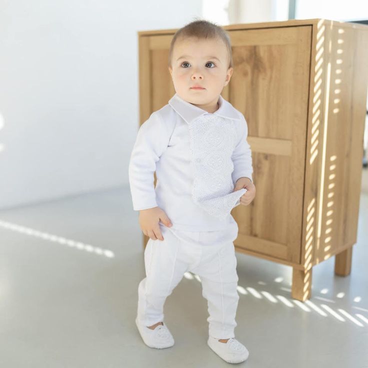 a little boy standing in front of a cabinet