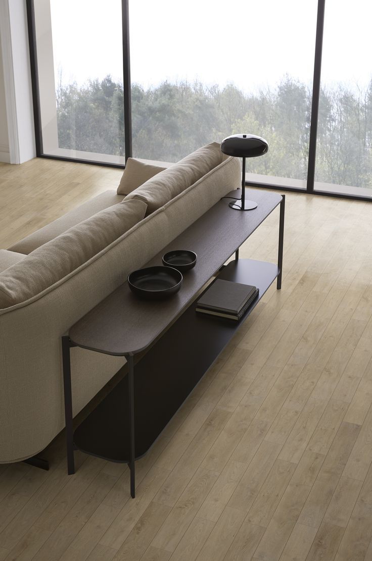 a couch sitting on top of a wooden floor next to a table with two black plates