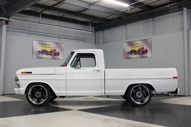 an old white pickup truck parked in a garage