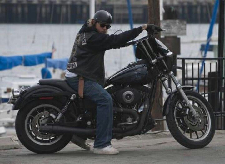 a man riding on the back of a black motorcycle