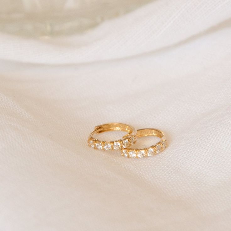 Sparkly and dainty, you'll never want to take these Classic CZ Huggie Hoop Earrings out! Crafted with 14k solid gold, these are the perfect heirloom pieces that you can count on wearing every day. They're teeny and lightweight so they're comfortable for 24/7 wear. Take them to the beach with you, or pair them with a bigger set of hoops on a night out - they're ready for any outing and will definitely boost your confidence along the way! DETAILS 14k solid gold huggies 12mm diameter, 2mm thickness Gold Huggies, Types Of Gold, Huggie Hoop Earrings, Favorite Rings, Pure Gold, 22k Gold, 10k Gold, Gold Rose, Rose Gold Plates