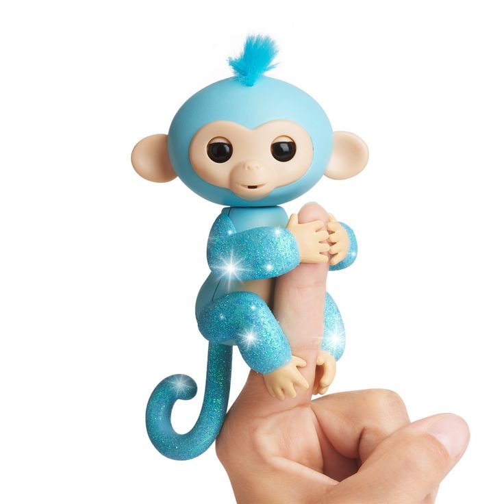 a hand holding a small toy monkey on it's finger with blue glitters