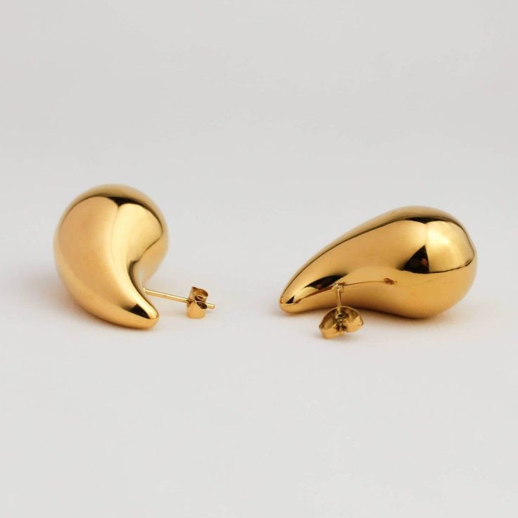 With these Bottega drop gold earrings, all that glitters is gold. Inspired by the iconic Italian fashion house Bottega Veneta, hand-finished, these statement earrings will add a touch of sophistication and glam to any outfit. The Bottega drop gold earrings feature a timeless design with delectably smooth edges and finishes. These are complemented with exquisite craftsmanship for a luxurious look that's guaranteed to turn heads. These earrings are fit for any occasion, effortlessly taking you fro Gold-plated Teardrop Earrings For Party, Gold Plated Teardrop Earrings For Party, Gold Dangle Drop Earrings For Party, Gold Plated Drop Earrings With Shiny Finish, Modern Gold Earrings For Party, Gold-tone Teardrop Earrings, Gold Shiny Finish Drop Earrings, Gold Drop Earrings With Shiny Finish, Gold Single Drop Earring For Formal Occasions