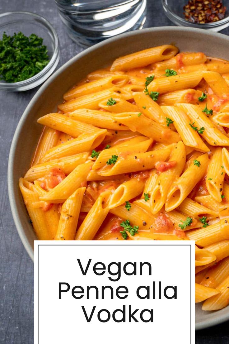 vegan penne alla vodka in a bowl with herbs and seasonings on the side