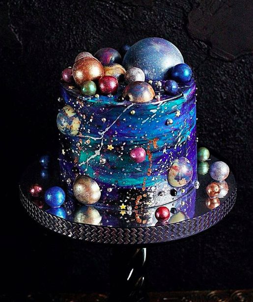 an image of a cake decorated with balls and stars on the top, sitting on a table