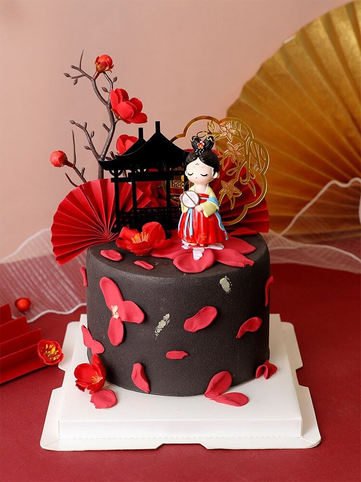 there is a cake decorated with red and black decorations on top of the cake stand