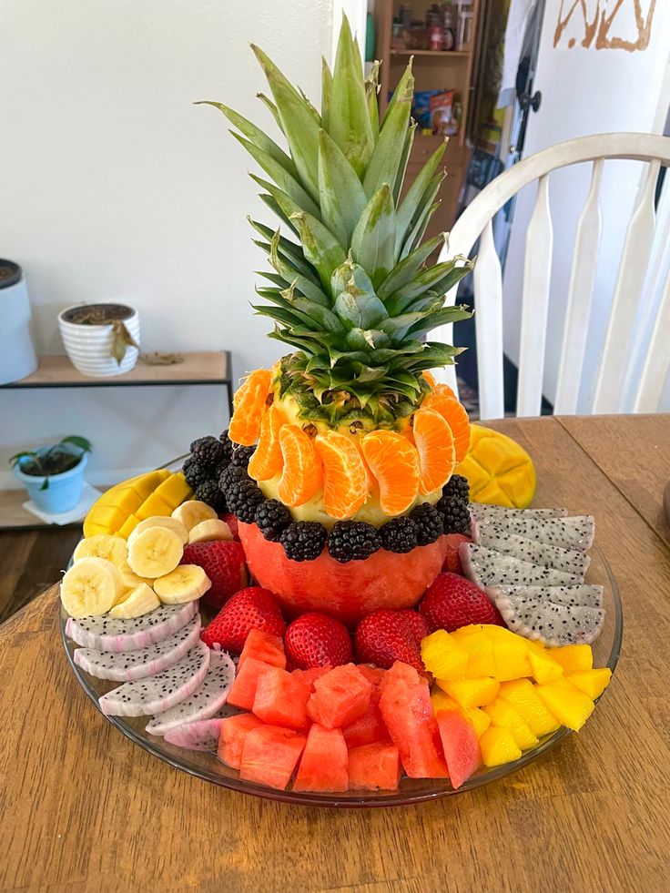 a platter filled with sliced up fruit on top of a wooden dining room table