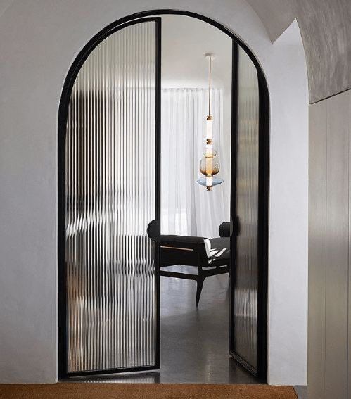 an arched glass door leading to a dining room