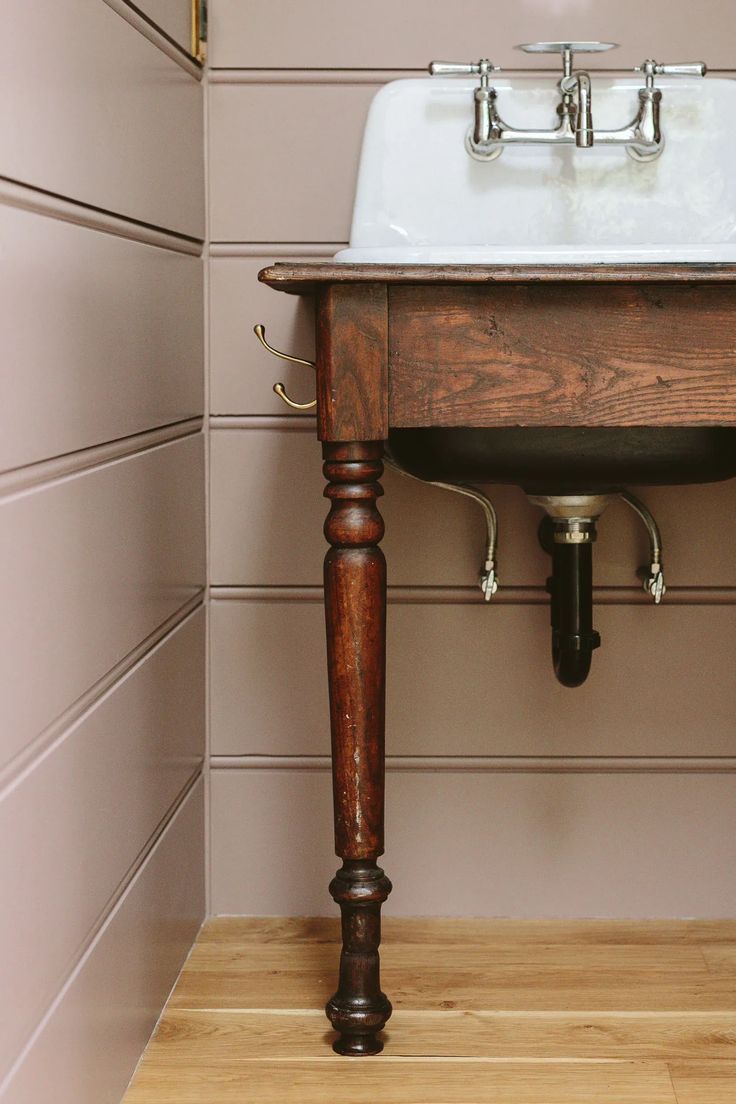 a bathroom sink sitting on top of a wooden counter next to a wall mounted faucet