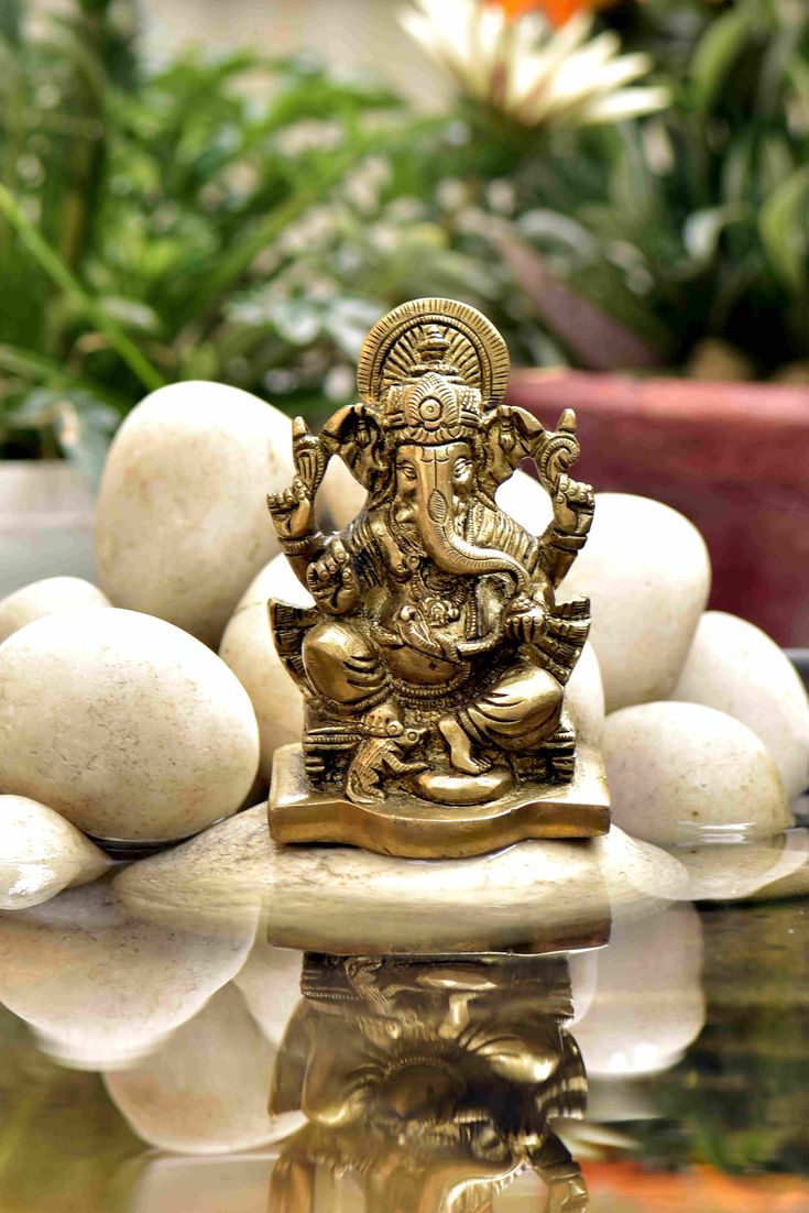 a statue of an elephant surrounded by rocks and plants