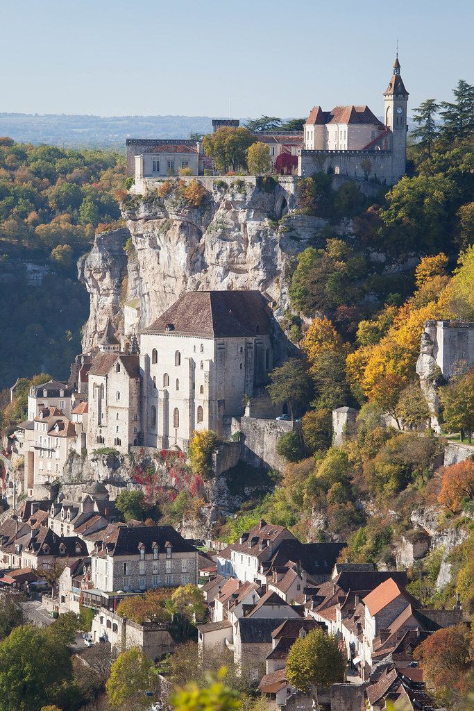 an old town on top of a hill surrounded by trees