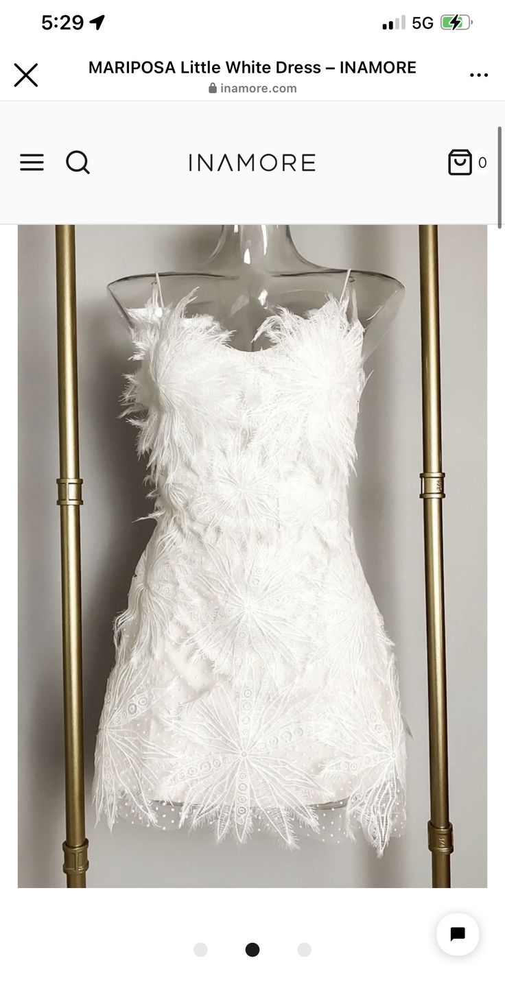 a white dress is hanging on a rack