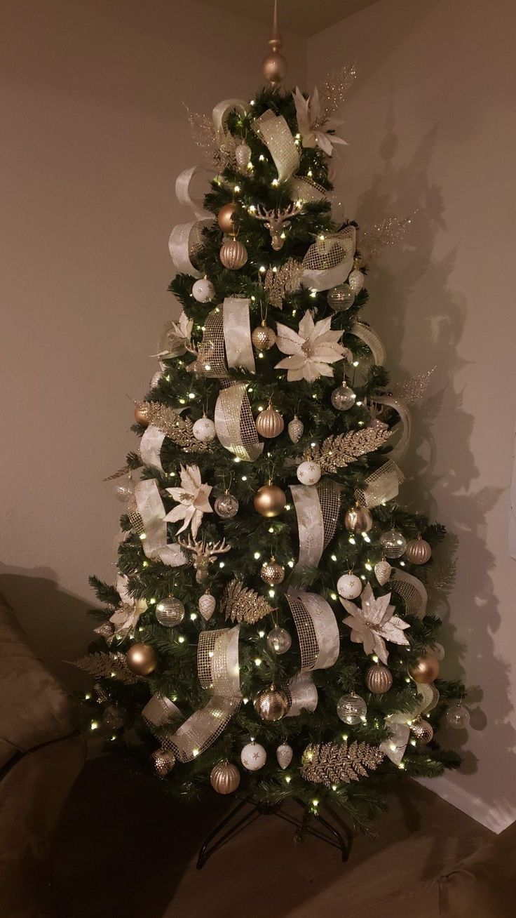 a decorated christmas tree with white and gold ornaments