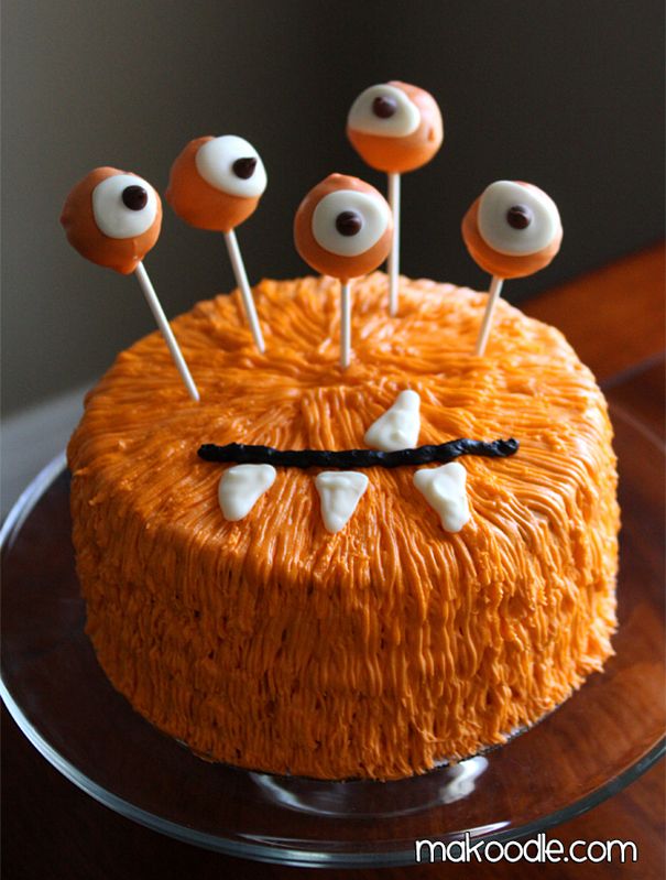 an orange cake with eyes and sticks sticking out of it