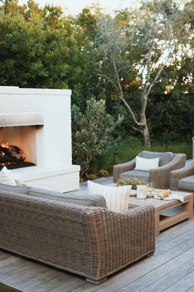 an outdoor patio with wicker furniture and fireplace